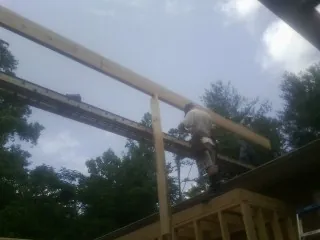 Carpenter setting a ridge beam over a new addition frame — Ice Dam Removal by Roofing Brothers in Corydon