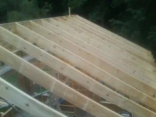 New roof rafters set over an addition before sheathing in Corydon