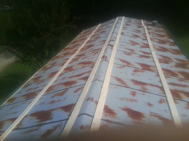 Rusted metal roof panels with new wood purlins before replacement — Storm Damage Roof Repair in Corydon by Roofing Brothers
